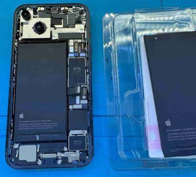 Batteria originale Apple per iPhone 14 accanto al telefono smontato